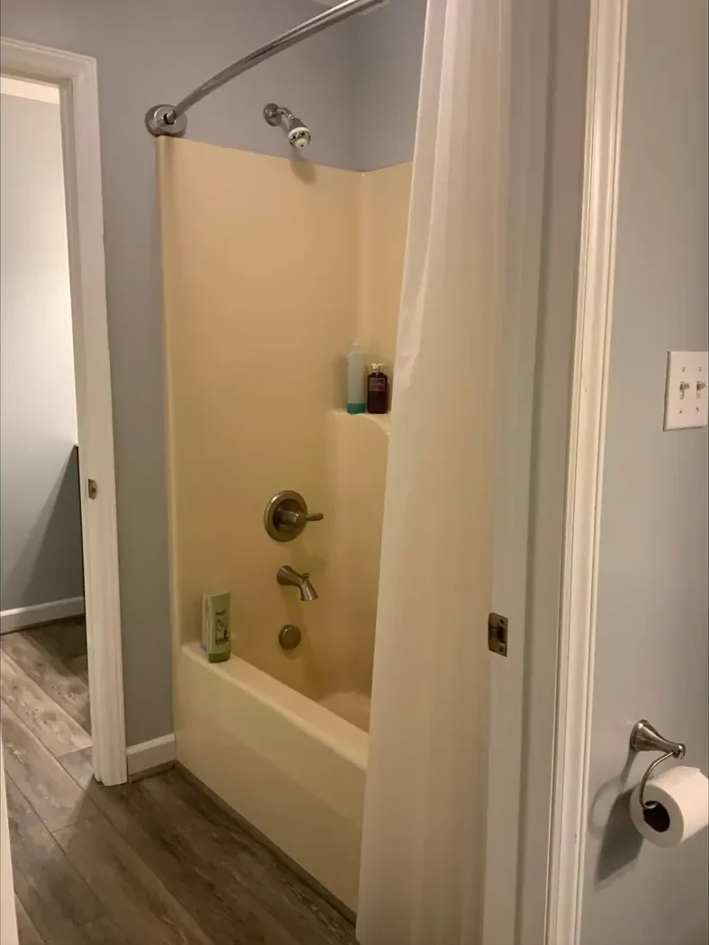 Worn tub and shower surround with dated fixtures before remodeling
