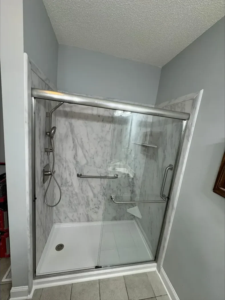 Low-entry stone-look shower with a glass door after remodeling